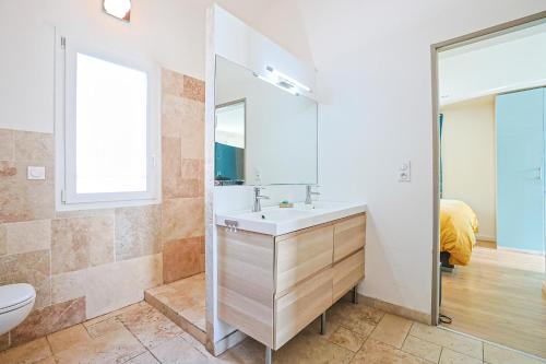 a bathroom with a sink and a toilet and a mirror at Maison avec Piscine et Jacuzzi Proche des plages in Toulon