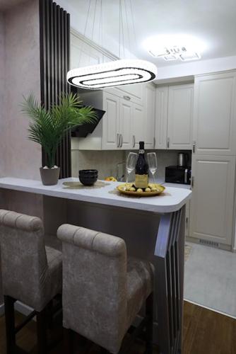 a kitchen with a island with two bar stools at Imperial Lux Apartment in Kragujevac