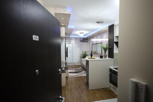 a kitchen with a black door and a kitchen with a counter at Imperial Lux Apartment in Kragujevac