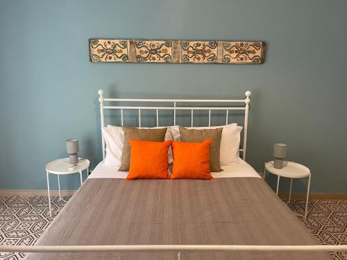 een bed met oranje kussens in een blauwe slaapkamer bij Casa Marì Holiday House in Palermo