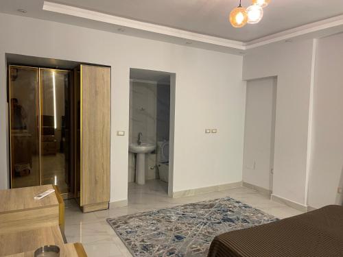 Ein weißes Zimmer mit einem Bett und einem Bad. in der Unterkunft شقة فندقية غرفتين بكمبوند قرب ميدان جهينة in Sheikh Zayed