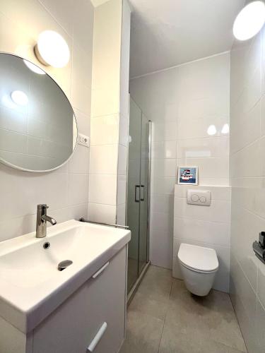 ein Badezimmer mit Waschbecken, Toilette und Spiegel in der Unterkunft Apartments Martina in Primošten