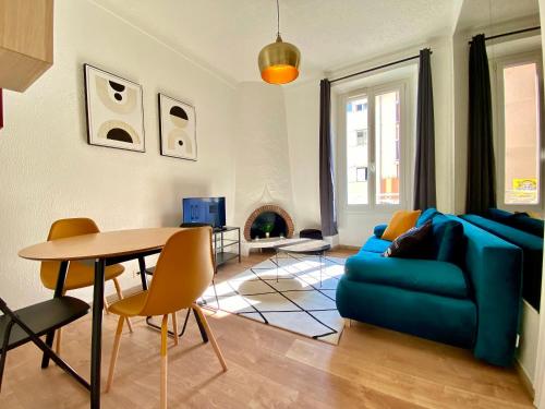 un salon avec un canapé bleu et une table dans l'établissement Volupté By SCLS Locations, à Cannes