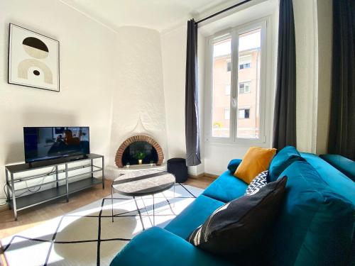 un salon avec un canapé bleu et une cheminée dans l'établissement Volupté By SCLS Locations, à Cannes