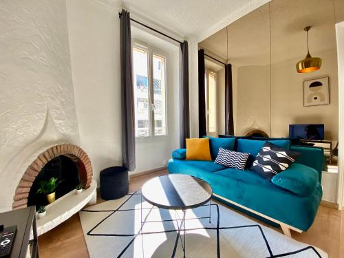 un salon avec un canapé bleu et une cheminée dans l'établissement Volupté By SCLS Locations, à Cannes