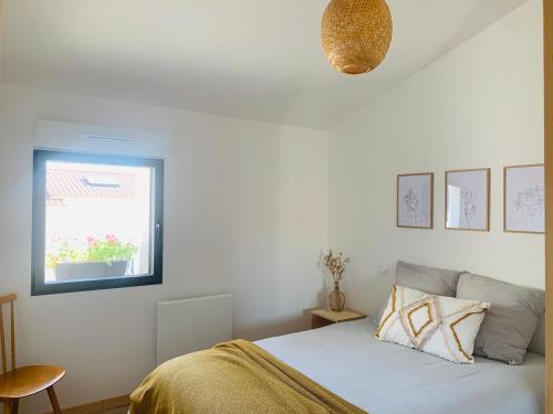 une chambre blanche avec un lit et une fenêtre dans l'établissement Le Solier, gîte à la campagne, à Frossay