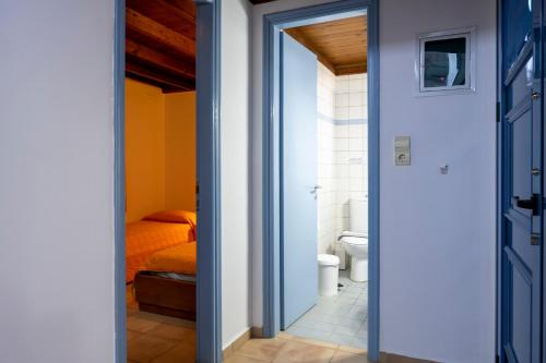 a room with a bed and a bathroom with a toilet at Olive Garden Houses in Palekastron