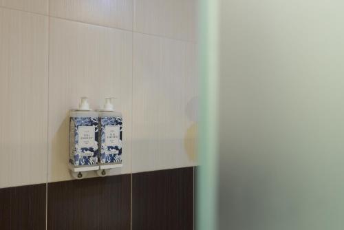 a bathroom with blue and white bottles on a wall at Hotel Baltum in Albufeira