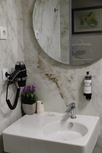 a bathroom with a white sink and a mirror at Bemyguest - Loft Guest House Jardim das Mães Charming in Viseu
