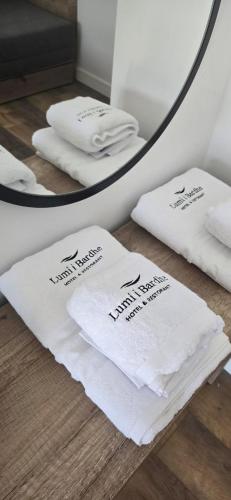 two towels sitting on the floor in front of a mirror at Lumi i Bardhe Hotel & Restaurant in Kuç