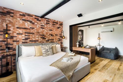 a bedroom with a bed and a brick wall at ULIV Roma Norte in Mexico City