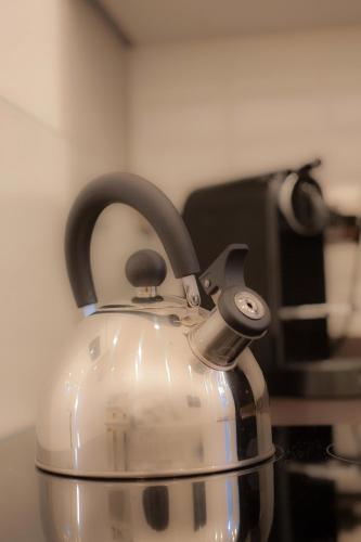 a tea kettle with black handles sitting on a stove at Sotrani in Trani