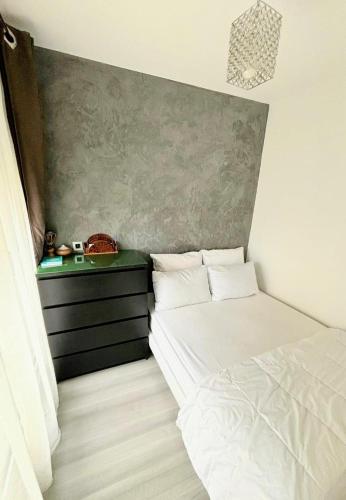 - une petite chambre avec un lit et une commode dans l'établissement Charmant Appartement très bien localisé avec Parking, à Puteaux