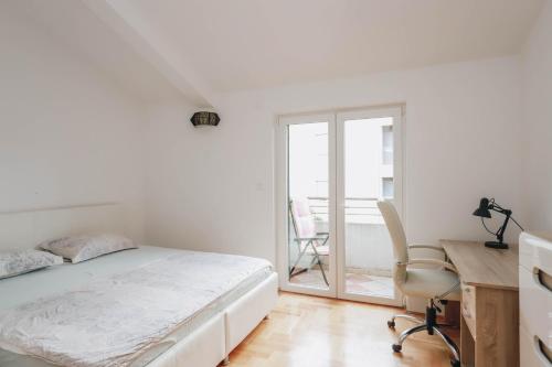 a bedroom with a bed and a desk and a chair at Duplex 3 bedrooms on the first line in Petrovac in Petrovac na Moru