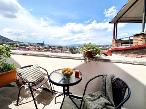 a table with a bowl of fruit on a balcony at Betlemi Old Town Hotel in Tbilisi City