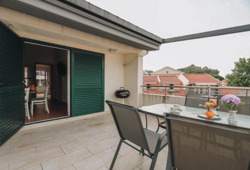 a patio with a table and chairs on a balcony at Duplex 3 bedrooms on the first line in Petrovac in Petrovac na Moru