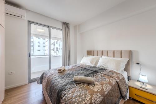 un dormitorio con una cama y una ventana grande en Ana's Home, en Durrës