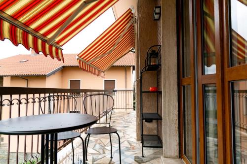 a patio with a table and chairs on a balcony at Appartamento Paprika 1966 una comfort zone in Savigliano