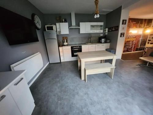 - une cuisine avec une table en bois et une table dans l'établissement Maison confortable au Havre 58 m² calme et pratique, au Havre
