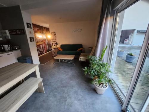 un salon avec un canapé vert et des plantes en pot dans l'établissement Maison confortable au Havre 58 m² calme et pratique, au Havre
