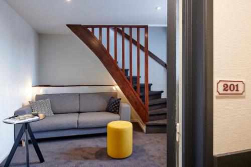 a living room with a couch and a staircase at Hôtel de France - Beaune in Beaune