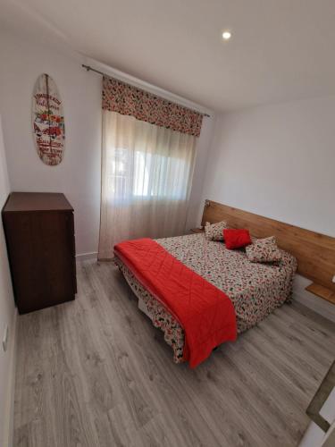 a bedroom with a bed with a red comforter at Del Rodriguez in Cunit