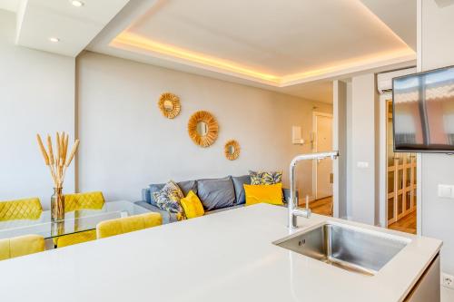 a kitchen and living room with a blue couch at Hanami Avenida de España La Gaviota in Estepona