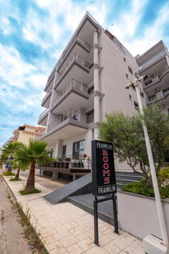 a building with a sign in front of it at Franklin Rooms in Sarandë