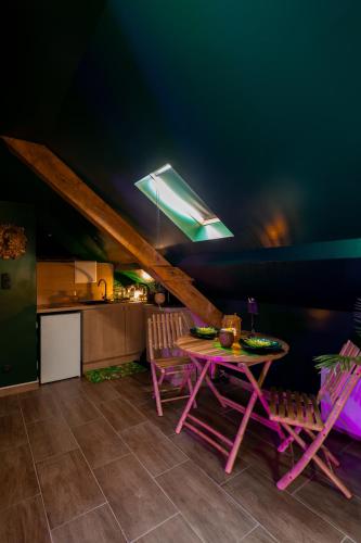 a dining room with a pink table and chairs at Dynasty Jungle Home Spa Jacuzzi in Holtzheim