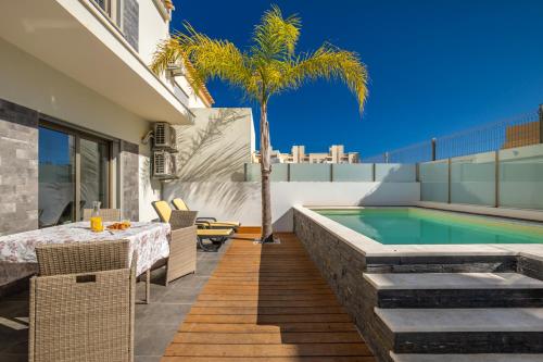a backyard with a pool and a table and a palm tree at Lovely Home, WIFI, Jardim in Armação de Pêra