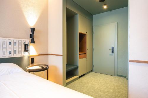 a bedroom with a bed and a walk in closet at Upside Down Town Hotel Neue Post in Zell am See