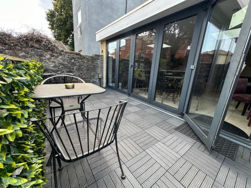 a patio with a table and chairs on a deck at Number One Hundred Bed And Breakfast in Cardiff