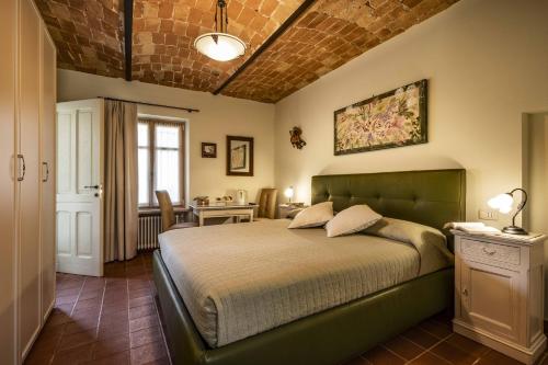 a bedroom with a bed and a table in it at La Cascina Della Musica in Costigliole dʼAsti