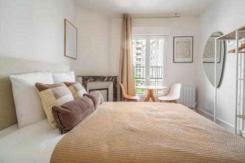 une chambre avec un grand lit et une table dans l'établissement Appartement Neuf Banlieue Parisienne - Montreuil, à Montreuil