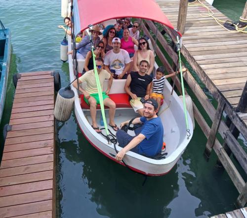 a group of people sitting in a boat on the water at Tortugal Boutique River Lodge in Rio Dulce