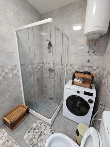 ein Badezimmer mit Dusche und Waschmaschine in der Unterkunft Apartment Vento di Bocche III in Kotor