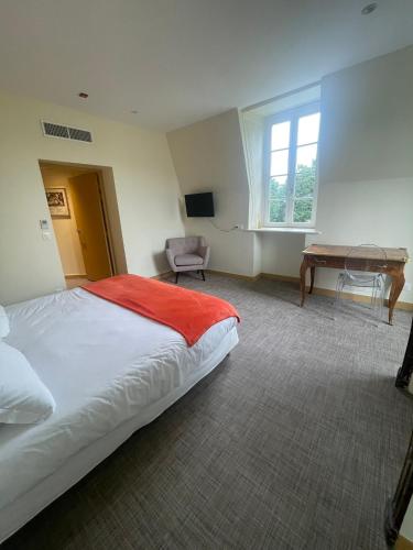 une chambre avec un lit, un bureau et une fenêtre dans l'établissement Il Maestro - hôtel Restaurant du Château, à Écouen