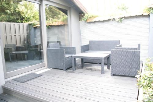 un patio con mesa y sillas en un porche en Studios Jps en Les Flaches