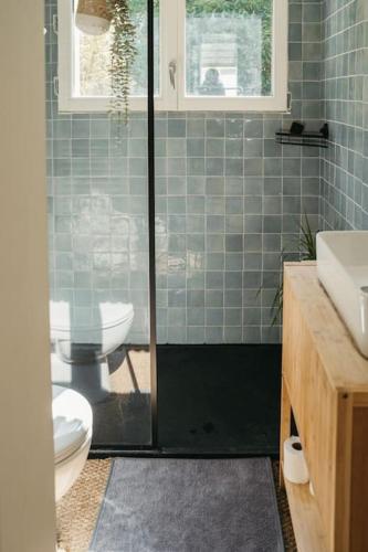 une salle de bain avec toilettes et douche en verre dans l'établissement Charmante petite maison avec piscine, à Bordeaux