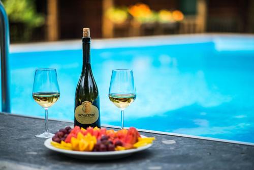 a bottle of wine and two glasses of grapes at Wooden Village Resort in Ponari