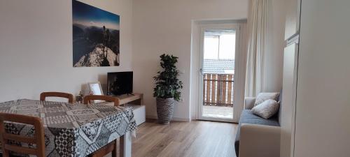 a dining room with a table and a chair and a window at Erica in Folgaria