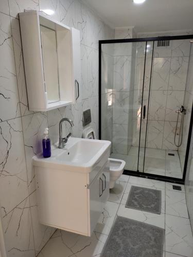 a white bathroom with a sink and a shower at Garden Prizma Rooms&Aparts in Kemer