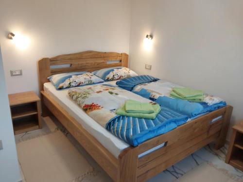 a bedroom with a wooden bed with blue pillows at Villa Sunce Funtana in Funtana