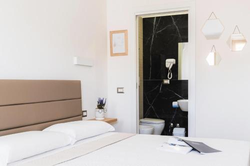 a bedroom with a bed and a bathroom with a toilet at Art Boutique Rooms in Le Castella