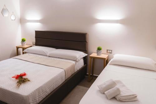 a bedroom with two beds with a red bow on them at Art Boutique Rooms in Le Castella