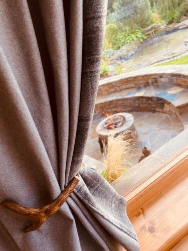 a curtain in a window with a view of a garden at Pensjonat Orlik Mountain Resort&SPA in Bukowina Tatrzańska