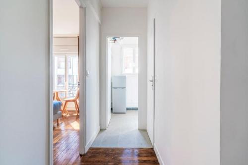 un couloir avec une porte s'ouvrant sur un salon dans l'établissement Studio ensoleillé aux portes de Paris - Montreuil, à Montreuil