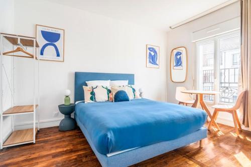 - une chambre avec un lit bleu et une table dans l'établissement Studio ensoleillé aux portes de Paris - Montreuil, à Montreuil
