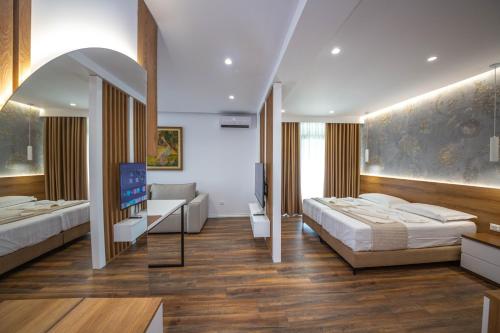a bedroom with two beds and a tv in it at Downtown Boutique Studios in Tirana