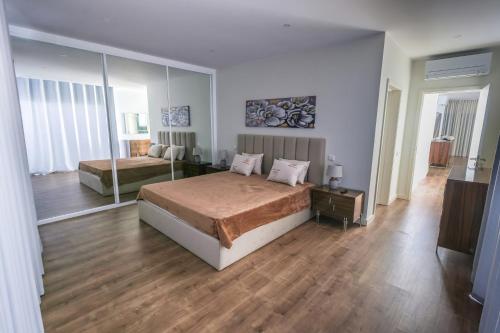 ein Schlafzimmer mit zwei Betten und einem großen Spiegel in der Unterkunft Casa do Beco do Barlavento in Vila Baleira